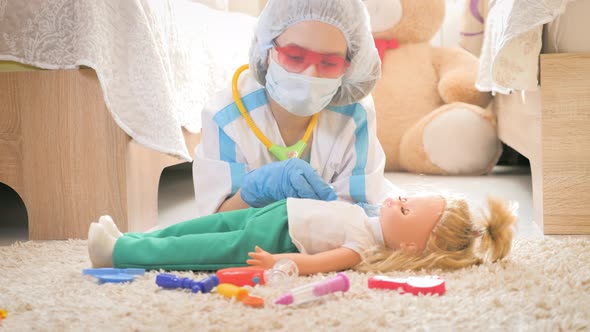 Beautiful Little Girl Playing Doctors with Doll at Home alt
