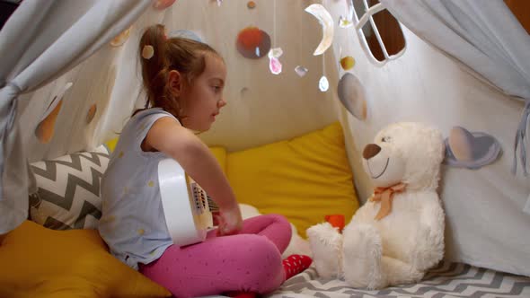 Cheerful Little Girl Plays Small Guitar Sings Songs to a Teddy Bear Tent Home alt