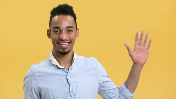 Portrait of Happy Arab Guy with Dark Hairdo and Mustache Waving Hand and Welcoming Isolated Over alt