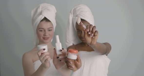 Beautiful Female Models Showing Beauty Products on Grey Background alt