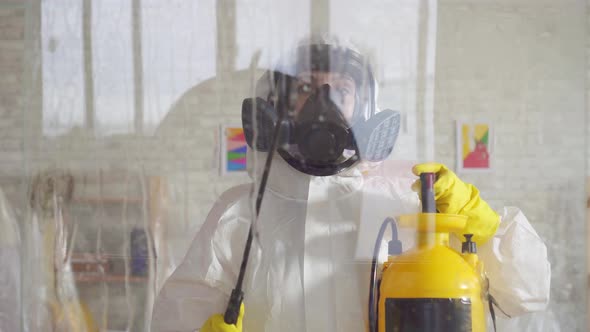 Close Up Exterminator in Overalls Carries Out Surface Treatment By Means of a Spray alt