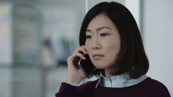 Japanese business woman in office talking on phone