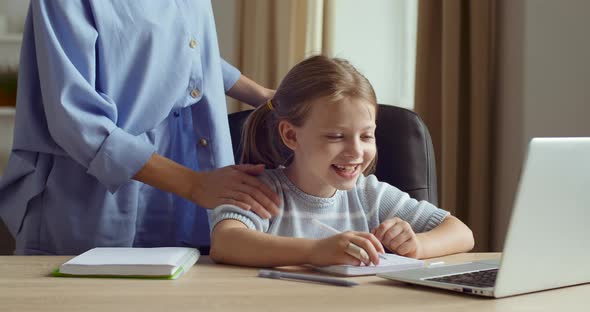 Girl Sits at Home, Studies Online Remotely on E-learning, Looks at Laptop, Does Homework Exercises alt
