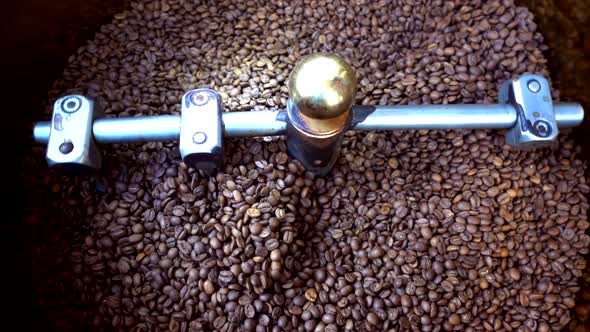 Mixing roasted coffee beans in roaster machine