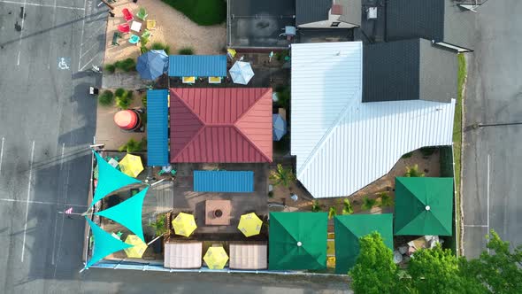 Top down aerial of outdoor restaurant, tiki bar. Colorful canopies and rooftop. America urban settin alt