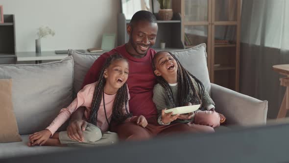 Dad Watching TV with Little Girls alt