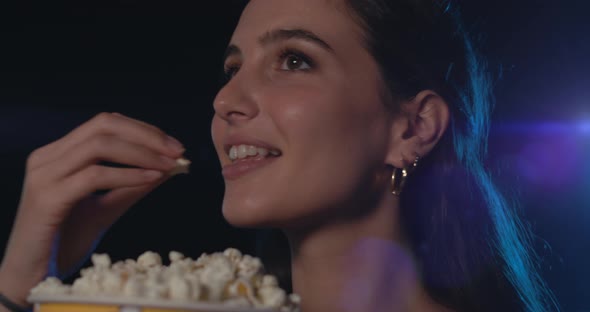 Women watching movies and eating popcorn at the cinema, video montage
