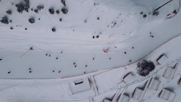Aerial view of ski resort with people skiing down the hill and up lift.