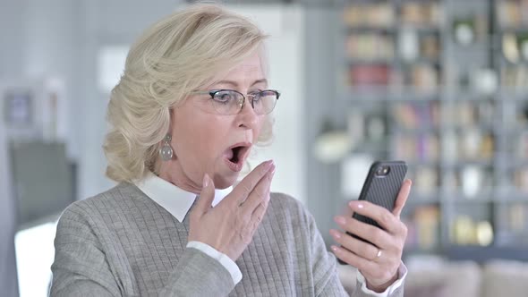 Portrait of Sad Old Woman Reacting To Loss on Smartphone alt