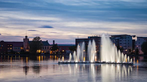 Eskilstuna, Sweden - May 31, 2021. Time lapse big fountain in city on twilight sunset sky