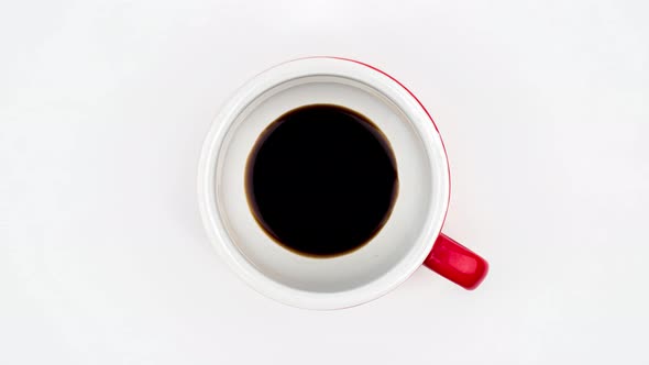 Top view stop motion of coffee pouring in cup isolated on white background.