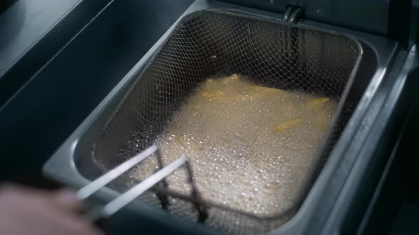 Chef Puts Raw Potatoe To the Boiling Oil for Making Fries in Slow Motion, Making the French Fries in