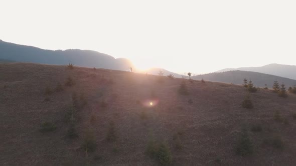 Newlyweds Dancing on a High Slope of the Mountain. Groom and Bride. Aerial View alt