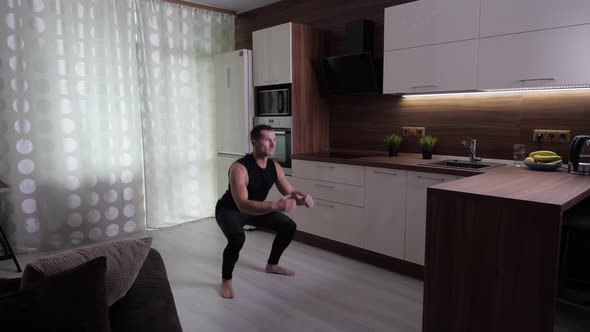 The Athlete Trains Hard at Home, Performing Jumps From the Squat