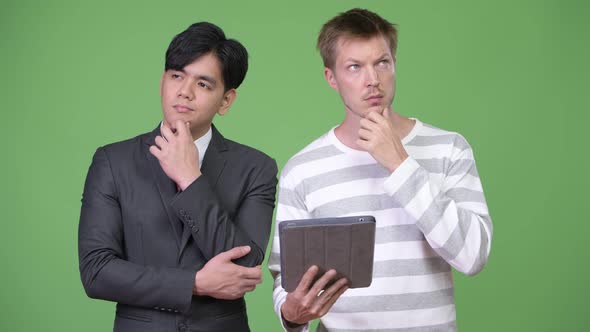 Young Handsome Asian Businessman and Young Scandinavian Businessman Working Together alt