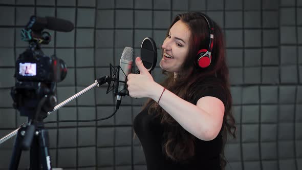 Young female vlogger recording a video of herself talking to the camera. Voiceover and dubbing alt