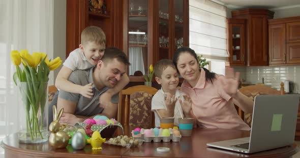 Mom Dad and Two Boys are Sitting at a Table and Talking Video Call Using Computer alt