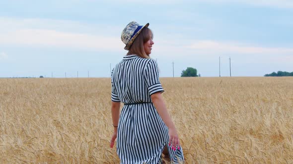 Happy Girl Goes Across Field Touches Ears of Wheat alt