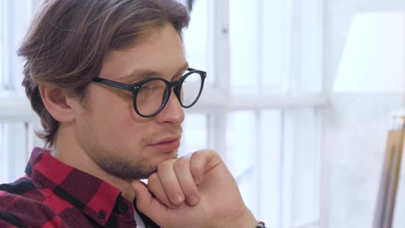Close-up of caucasian man using modern mobile smartphone sitting on a couch at home alt