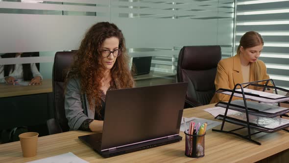 Coworker coming to the desk with a cup of coffee getting ready accomplishing projects. alt