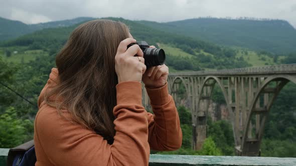 Closeup Young Woman Taking Pictures of Djurdjevic bridge. alt