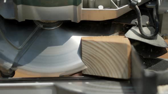 Cutting a Piece of Wood into Two Pieces with a Cut-Off Saw. alt