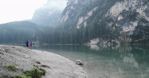 Man and Woman Couple Walking Near Braies Lake in Cloudy Day