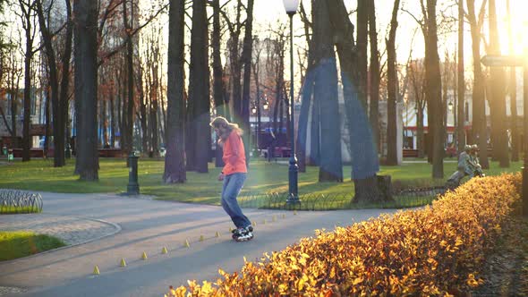Active and Athletic Man Performs Professional Roller Skating Technique in a Cool City Park. An alt