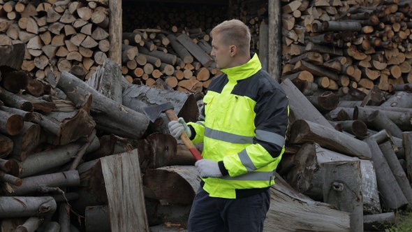 Lumberjack in Reflective Jacket. Man Woodcutter with Small Axe. Sawn Logs, Firewood Background alt