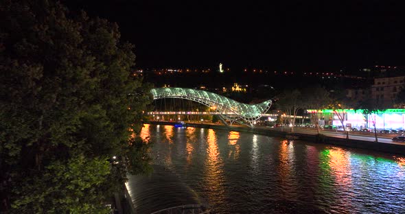 Night aerial view of Bridge of Peace and beautiful cityscape in the center of Tbilisi, Georgia 2022 alt