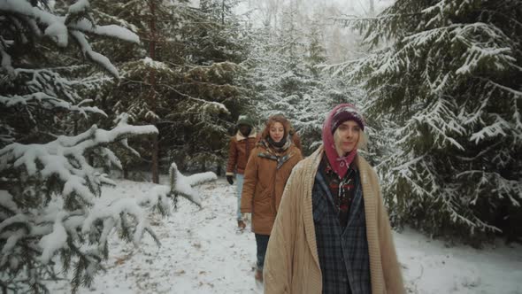 Young Tourists Walking through Winter Woods alt