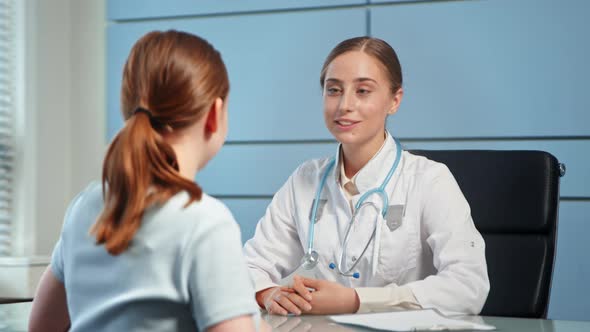 Blonde young woman doctor in white coat with stethoscope alt
