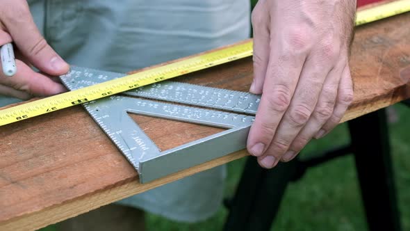 Slow Motion Woodworking Project, Male Hands Measuring Wood with Ruler and Marker in the Daytime alt