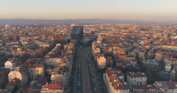 Boulevard in Sofia Bulgaria with City Traffic and Modern Architecture Building at Sunset alt