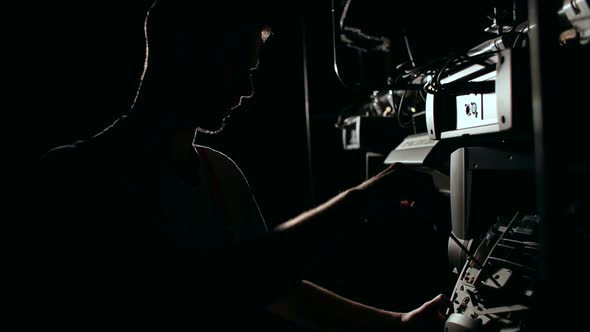 Silhouette of a Man Repairing Concert Equipment alt