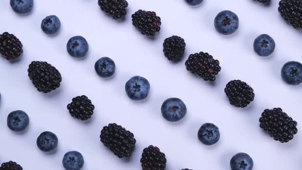 Rotating Blackberries and Blueberries on a White Background Closeup Top View