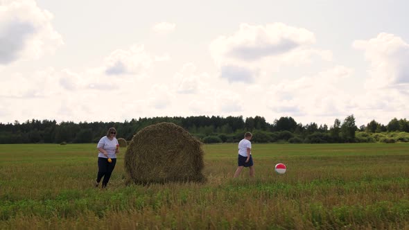 Funny Family with Their Son Run and Play Merrily Near the Haystack in the Field alt