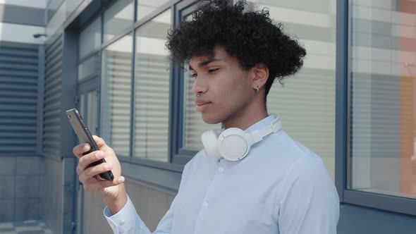 Happy Afro American Tourist in Headphones Listening to Music Outdoors Having Fun Alone in the Street alt
