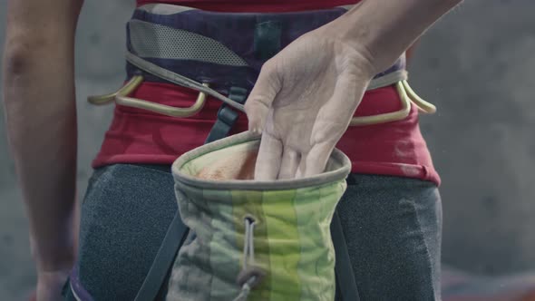 Sports Athletic Woman Uses Magnesium for Rock Climbing alt