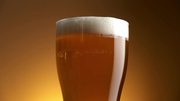 Circular Motion of Glass with Beer on Golden Background