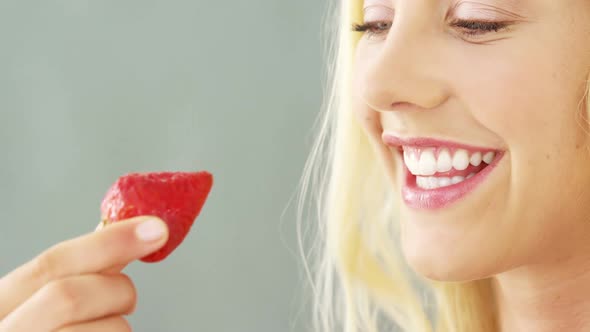 Close-up of beautiful woman eating strawberries in bowl alt