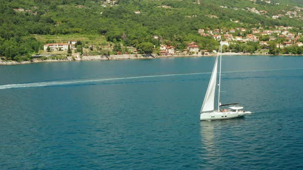 White Sailboat or Yacht Sails on the Sea with Blue Water alt