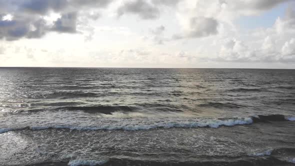 AERIAL: Revealing majestic view of the sea in the cloudy evening alt