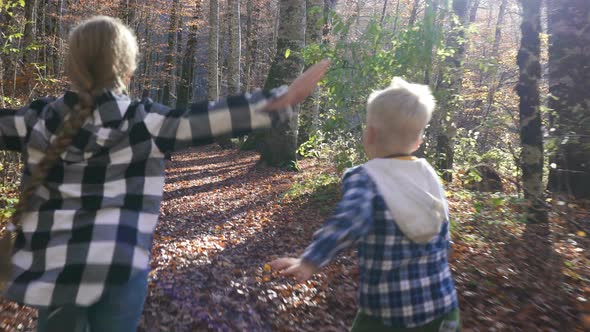 Little Carefree Children Happily Running Along the Forest Path with Both Their Arms Stretched Wide
