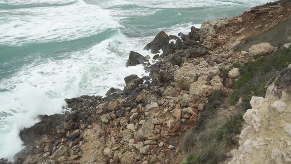 Big Mediterranean Sea Waves Crashes on Limestones on Golden Beach Bay Shore in Winter