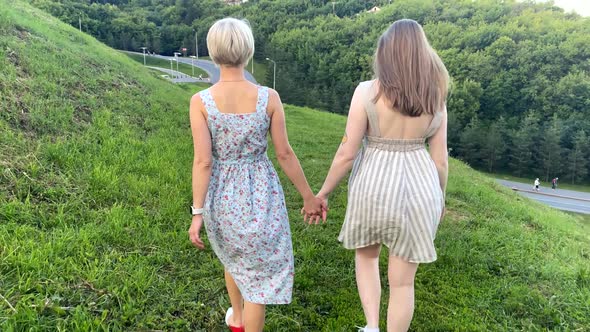 LGBT Couple Walking Through the Park Holding Hands