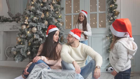 Portrait of Friendly Family in Santa Caps on Christmas