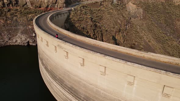 Aerial of a woman hiking across the Salmon Falls Dam in Southern Idaho alt