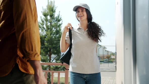 Smiling Woman with Thermal Bag Delivering Food to Male Customer's House alt