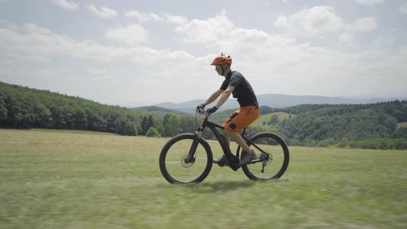 Video Mountainbiker on E Bike Cycling in Rural Landscape